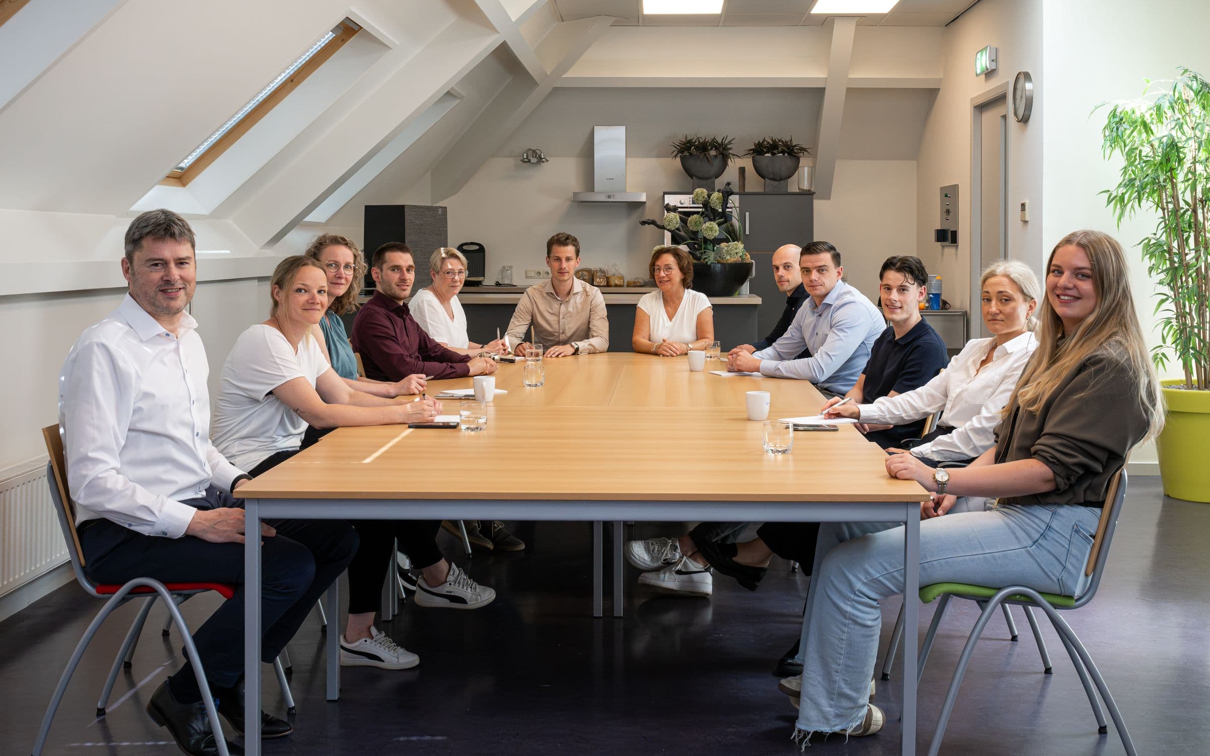 Het team van Accombis rond de lange tafel op kantoor in Bladel
