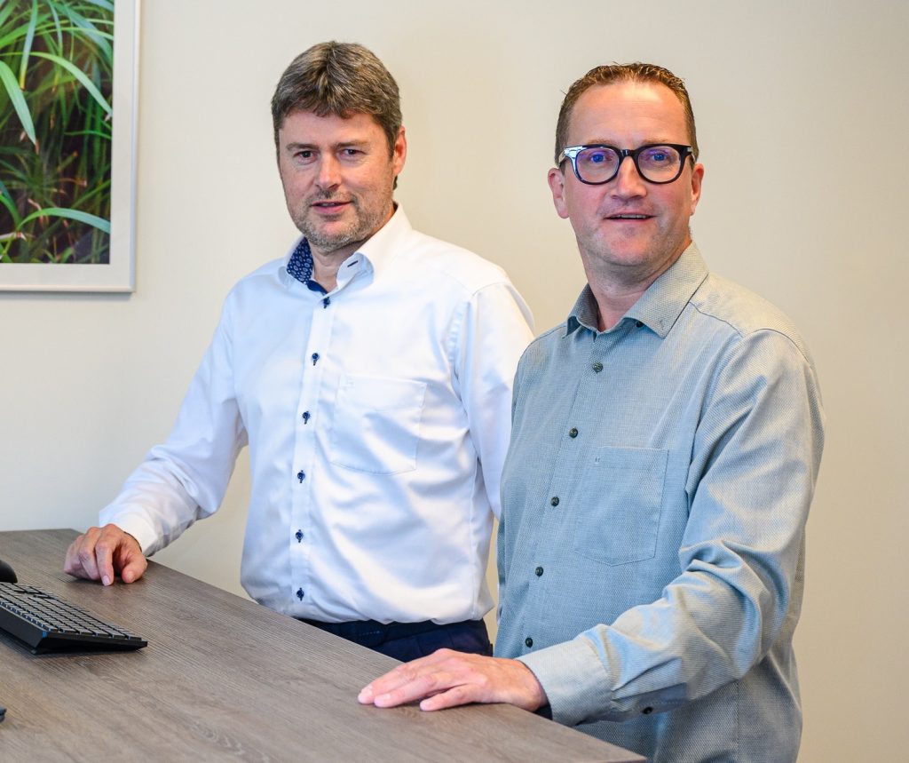 Twee mannen bij bureau.