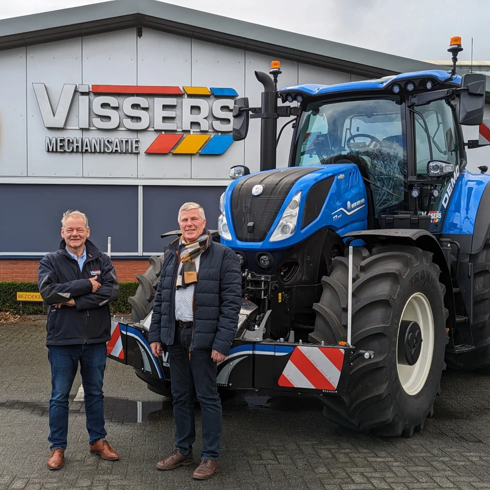 Twee mannen bij blauwe tractor voor Visser's Mechanisatie.