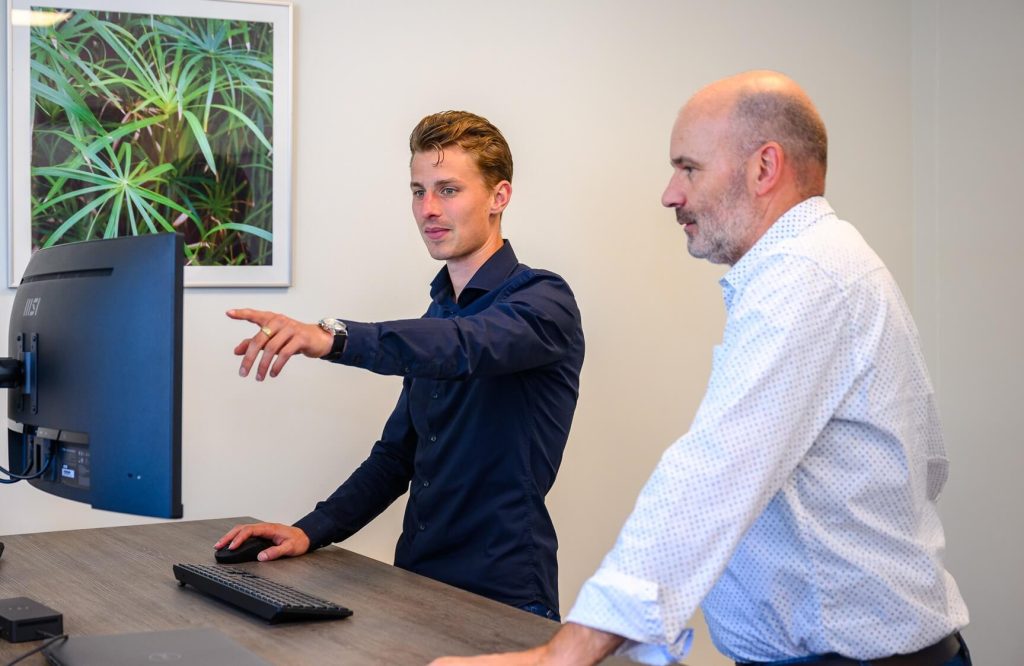 Twee mannen werken samen op een kantoor.