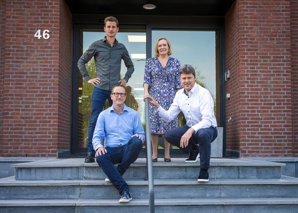 Vier personen op trappen voor een gebouw.